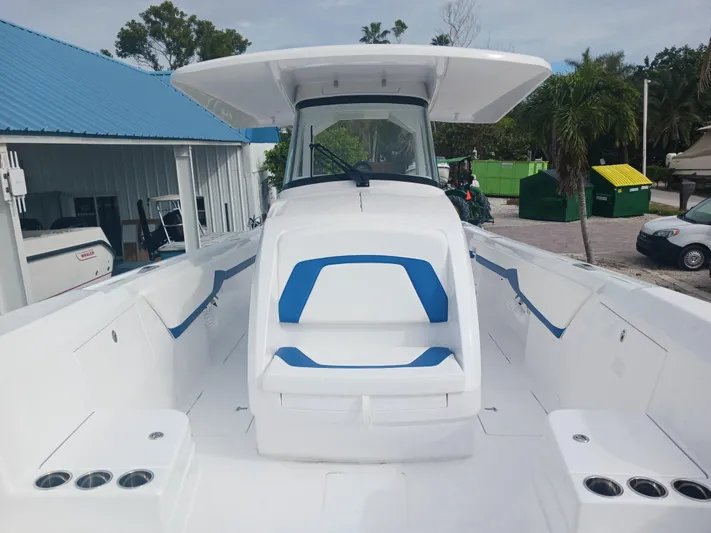  Yacht Photos Pics 2024 Intrepid 375 Nomad SE boat with blue accents, docked outdoors.