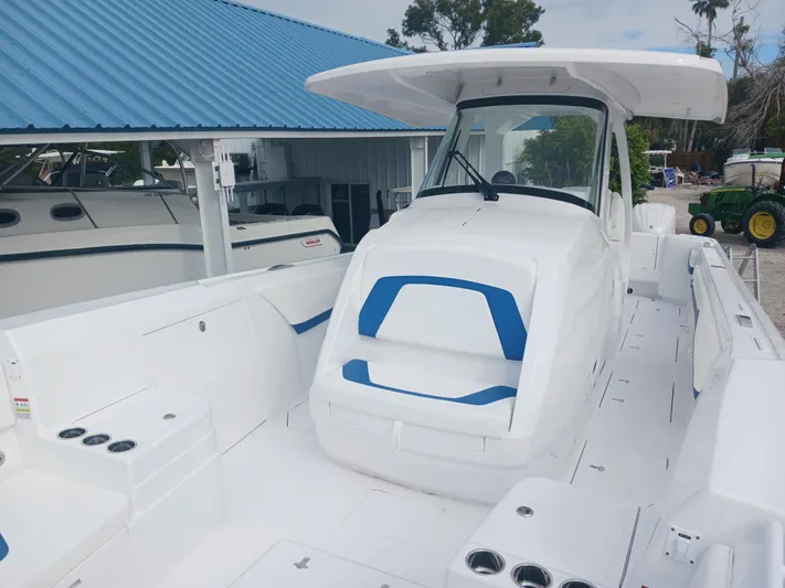  Yacht Photos Pics 2024 Intrepid 375 Nomad SE boat with blue accents, docked under a blue roof.