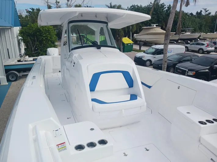  Yacht Photos Pics 2024 Intrepid 375 Nomad SE boat with sleek white and blue design, docked outdoors.