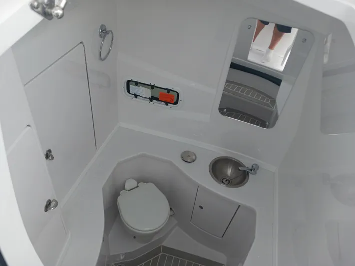  Yacht Photos Pics 2024 Intrepid 375 Nomad SE boat bathroom with toilet, sink, and mirror.