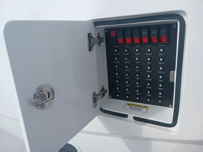  Yacht Photos Pics Electrical panel on 2024 Intrepid 375 Nomad SE boat, featuring labeled switches and open access door.