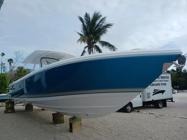  Yacht Photos Pics 2024 Intrepid 375 Nomad SE boat displayed outdoors with palm trees in the background.