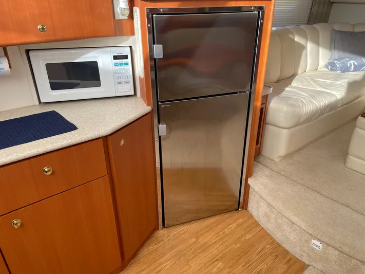  Yacht Photos Pics 1999 Silverton 392 Motor Yacht interior with microwave, stainless fridge, and cream seating.