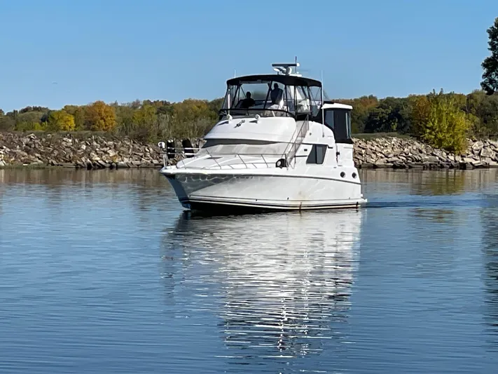  Yacht Photos Pics 1999 Silverton 392 Motor Yacht cruising on a calm lake with autumn trees in the background.
