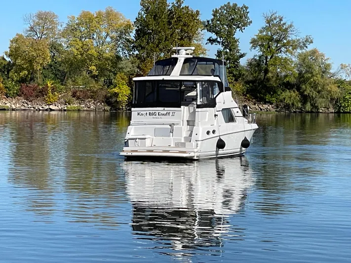  Yacht Photos Pics 1999 Silverton 392 Motor Yacht on calm water, surrounded by trees.
