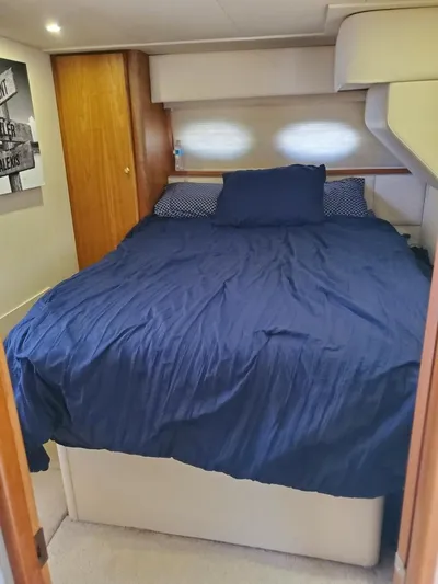  Yacht Photos Pics 1999 Silverton 392 Motor Yacht bedroom with blue bedding and wooden accents.