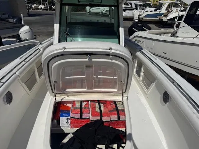  Yacht Photos Pics 2016 Boston Whaler 350 Outrage boat with open storage compartment, docked among other boats.
