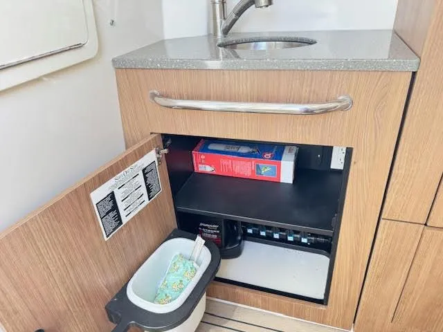  Yacht Photos Pics Interior of 2016 Boston Whaler 350 Outrage showing a sink and open cabinet storage.