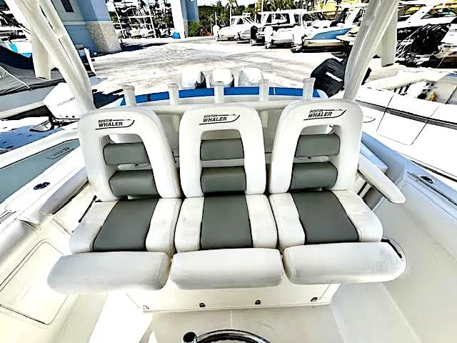  Yacht Photos Pics 2016 Boston Whaler 350 Outrage boat seating, featuring three cushioned seats in a marina setting.