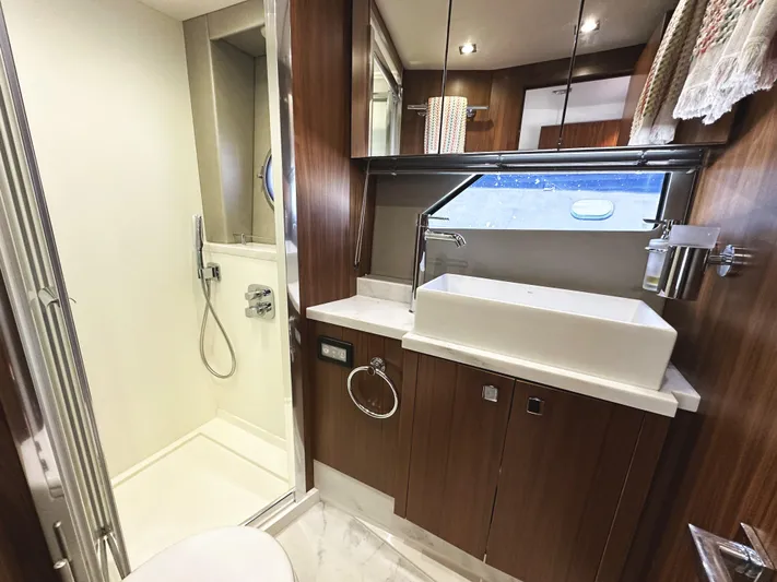 Forever Young Yacht Photos Pics Luxurious bathroom in 2019 Sunseeker Predator 57 yacht with modern fixtures and wood accents.