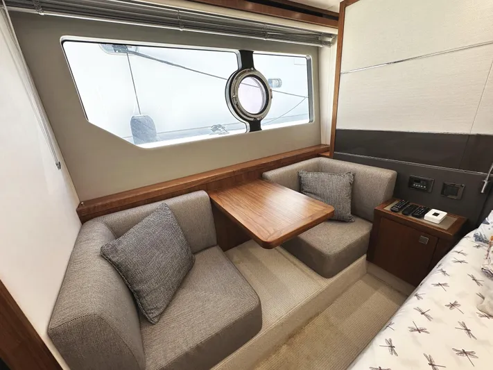 Forever Young Yacht Photos Pics Interior of 2019 Sunseeker Predator 57 yacht with cozy seating and wooden table.