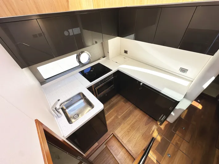 Forever Young Yacht Photos Pics Modern kitchen interior of 2019 Sunseeker Predator 57 yacht with sleek cabinetry and appliances.