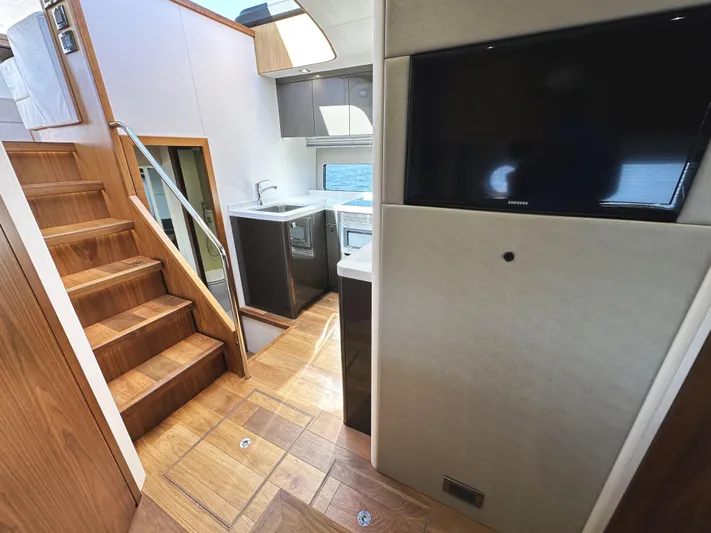 Forever Young Yacht Photos Pics Luxurious interior of 2019 Sunseeker Predator 57 yacht with wooden stairs and modern kitchen.