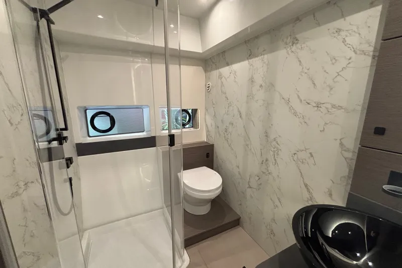  Yacht Photos Pics Luxurious bathroom in 2025 Beneteau Gran Turismo 50 yacht with marble walls and modern fixtures.