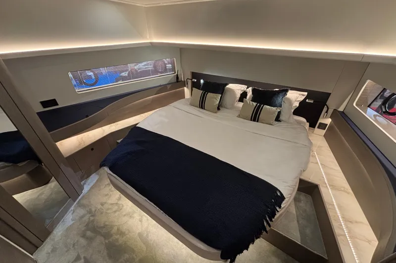  Yacht Photos Pics Luxurious bedroom interior of 2025 Beneteau Gran Turismo 50 yacht, featuring elegant bedding and modern design.