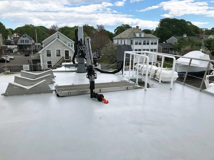 Care Bear Yacht Photos Pics Deck of 2013 Ocean Voyager 95 EXPEDITION yacht with crane and residential backdrop.