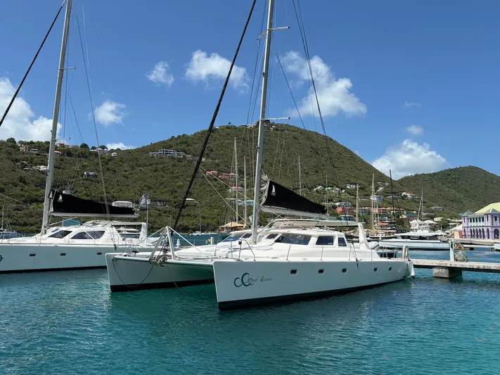 Windborne Yacht Photos Pics 2015 Voyage Yachts VOYAGE 520 catamaran docked in scenic marina with hills.