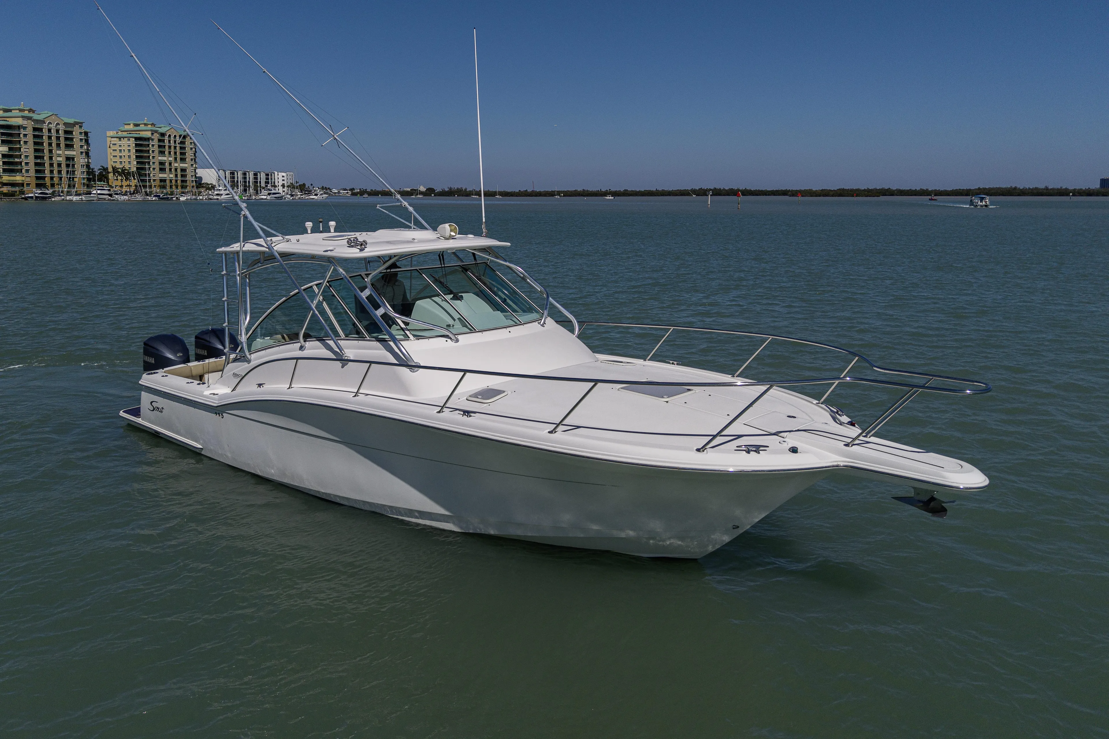 5 O' Clock Somewhere Yacht Photos Pics 2010 Scout 350 Abaco boat on calm water with cityscape background.