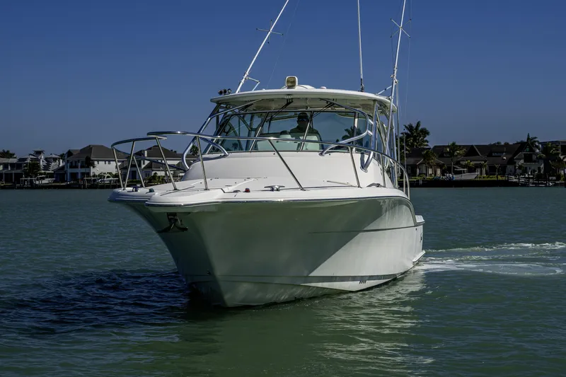 5 O' Clock Somewhere Yacht Photos Pics 2010 Scout 350 Abaco boat cruising on a sunny day near waterfront homes.