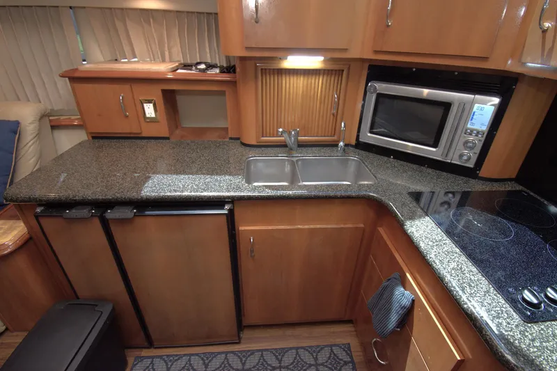 IV Play Too Yacht Photos Pics 2005 Carver 444 Cockpit Motor Yacht kitchen with granite countertops, sink, and microwave.