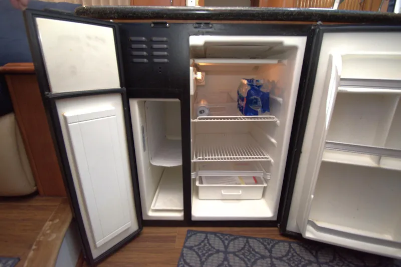 IV Play Too Yacht Photos Pics Open refrigerator in 2005 Carver 444 Cockpit Motor Yacht, showing interior storage space.