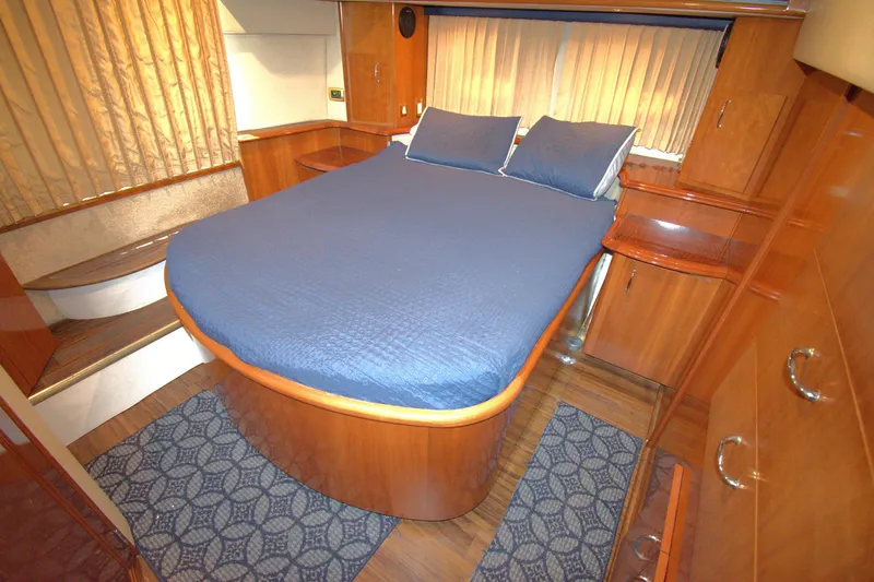 IV Play Too Yacht Photos Pics Luxurious 2005 Carver 444 Cockpit Motor Yacht bedroom with blue bedding and wooden cabinetry.
