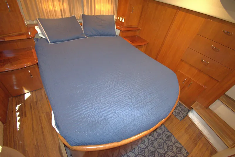 IV Play Too Yacht Photos Pics Interior of 2005 Carver 444 Cockpit Motor Yacht with blue bedding and wooden cabinetry.