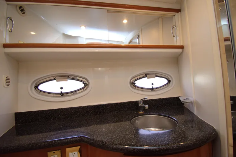 IV Play Too Yacht Photos Pics 2005 Carver 444 Cockpit Motor Yacht bathroom with granite countertop and oval portholes.