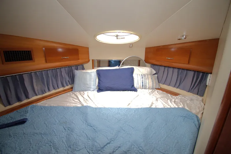 IV Play Too Yacht Photos Pics Cozy bedroom in 2005 Carver 444 Cockpit Motor Yacht with blue bedding and wood accents.