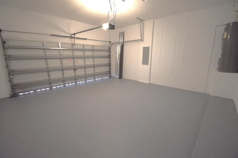 IV Play Too Yacht Photos Pics Empty garage interior with gray floor, white walls, and overhead door.