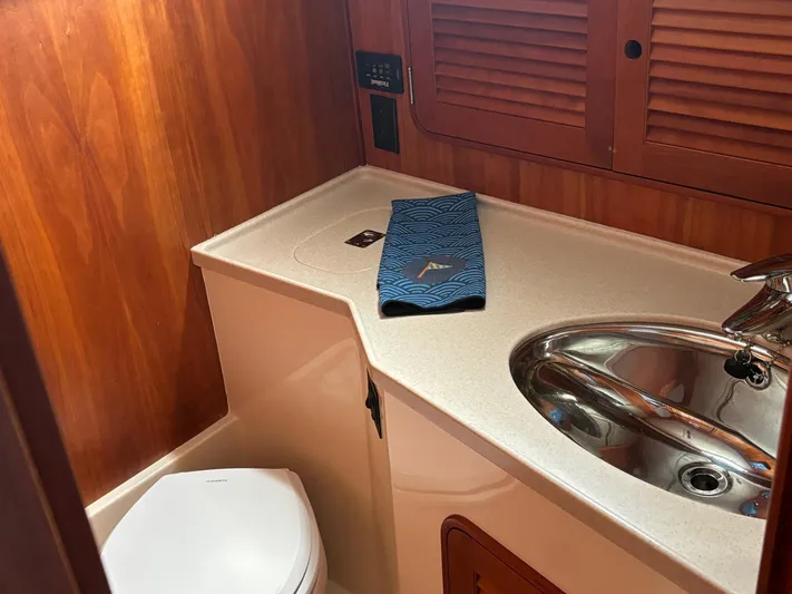 Mallard Yacht Photos Pics Hinckley Talaria 44 MY 2005 yacht bathroom with sink, toilet, and wooden cabinetry.