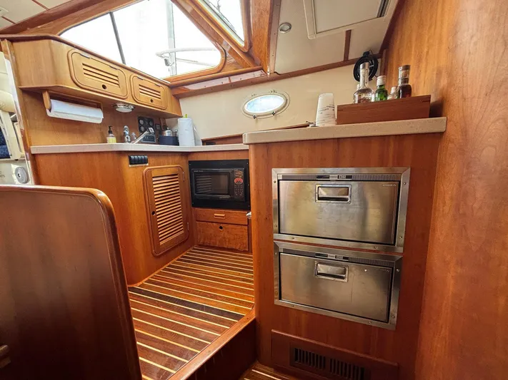 Mallard Yacht Photos Pics Hinckley Talaria 44 MY 2005 yacht interior with wooden cabinetry and stainless steel appliances.