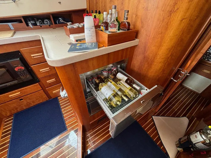 Mallard Yacht Photos Pics Hinckley Talaria 44 MY 2005 yacht interior with open wine drawer and wooden cabinetry.