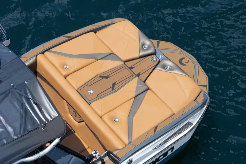  Yacht Photos Pics 2025 Centurion Nv233 boat with tan and gray cushioned deck on blue water.