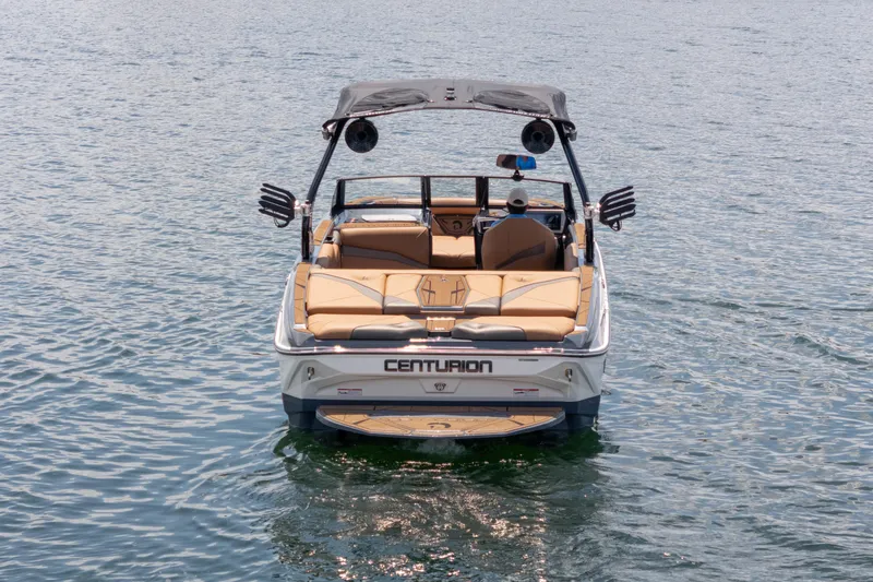  Yacht Photos Pics 2025 Centurion Nv233 boat on calm water, rear view with seating and speakers.