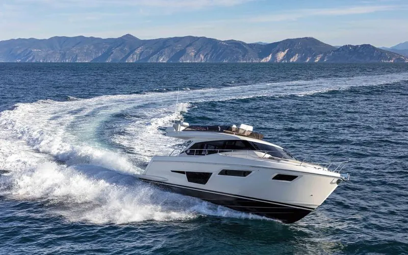 Yacht Photos Pics 2025 Ferretti Yachts 500 cruising on open sea with scenic mountain backdrop.