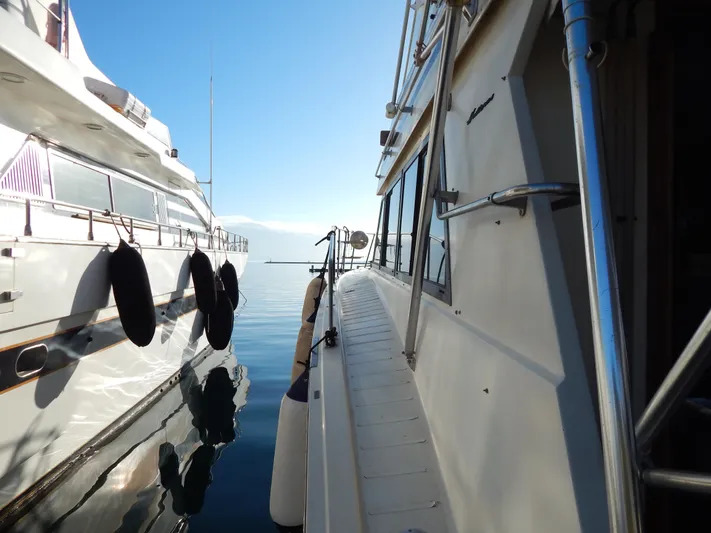  Yacht Photos Pics 1981 Hatteras 50 Convertible yacht docked beside another boat on calm water.