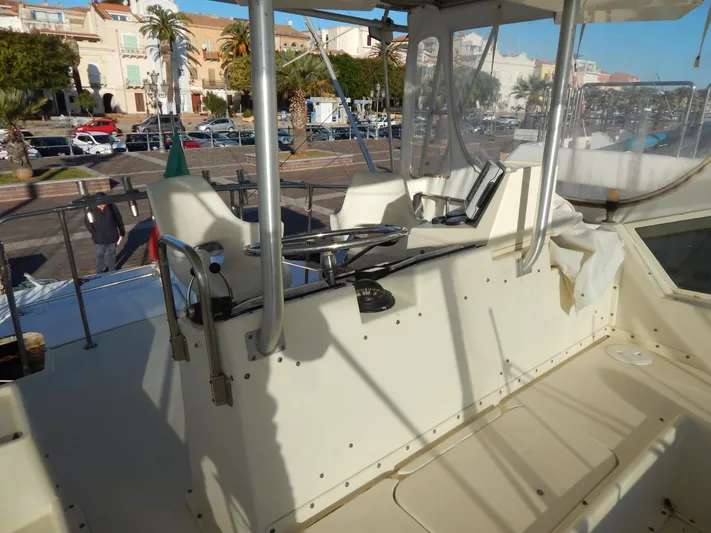  Yacht Photos Pics 1981 Hatteras 50 Convertible yacht helm with steering wheel and seating, docked in a marina.