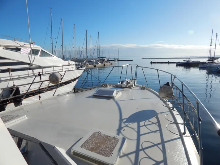  Yacht Photos Pics 1981 Hatteras 50 Convertible yacht docked in a serene marina under clear blue skies.