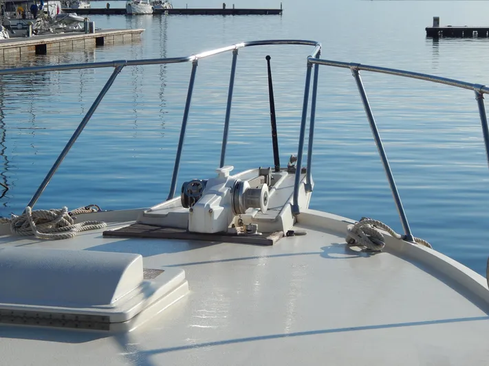  Yacht Photos Pics Bow of 1981 Hatteras 50 Convertible yacht at marina, calm water background.