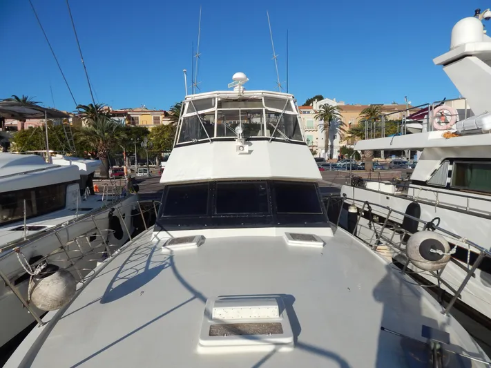  Yacht Photos Pics 1981 Hatteras 50 Convertible yacht docked in a sunny marina.
