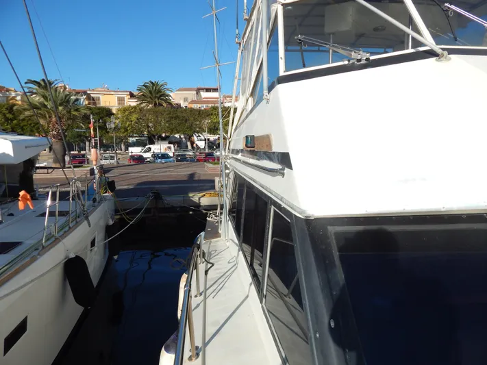  Yacht Photos Pics 1981 Hatteras 50 Convertible yacht docked at a marina under clear blue skies.