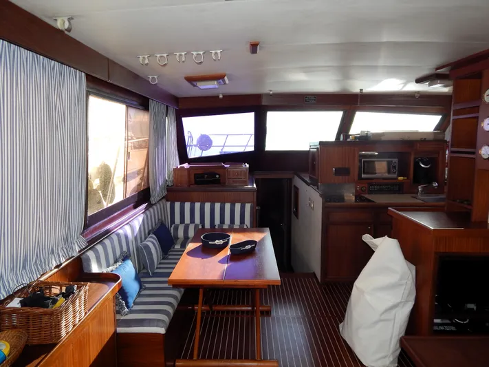  Yacht Photos Pics Interior of 1981 Hatteras 50 Convertible yacht with striped seating and wooden furnishings.