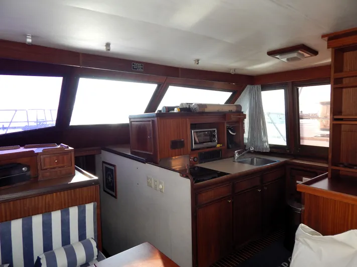  Yacht Photos Pics Interior of 1981 Hatteras 50 Convertible yacht with wood cabinetry and striped seating.
