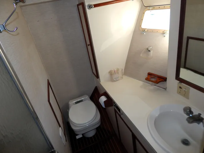  Yacht Photos Pics 1981 Hatteras 50 Convertible yacht bathroom with toilet, sink, and window.