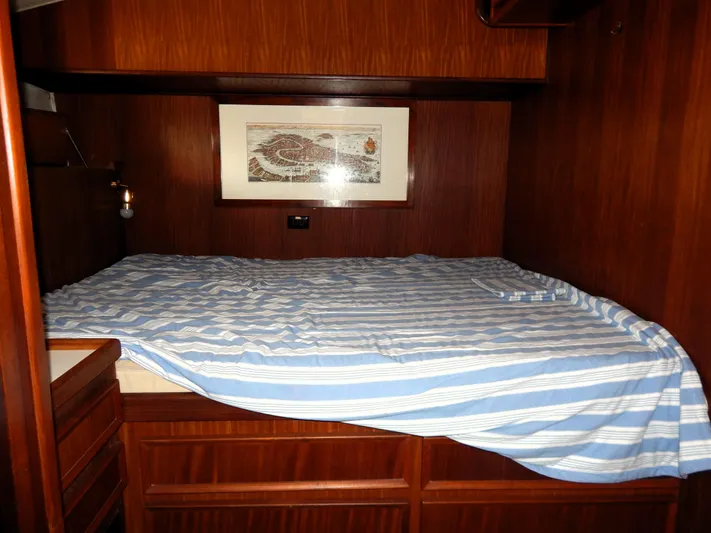  Yacht Photos Pics Cozy cabin interior of 1981 Hatteras 50 Convertible with striped bedding and wooden finish.
