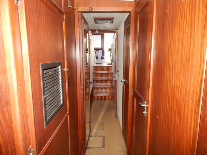  Yacht Photos Pics Interior hallway of 1981 Hatteras 50 Convertible yacht with wooden paneling and stairs.