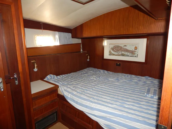  Yacht Photos Pics Cozy cabin interior of 1981 Hatteras 50 Convertible yacht with striped bedding.