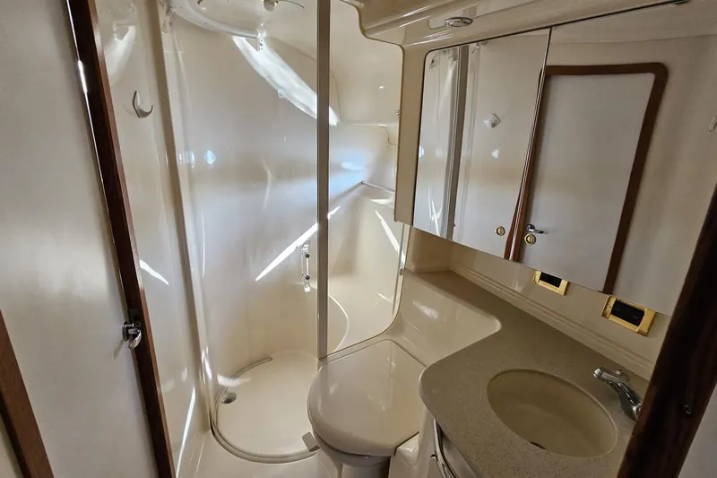  Yacht Photos Pics 1999 Sea Ray 460 Sundancer bathroom with shower, sink, and storage cabinets.