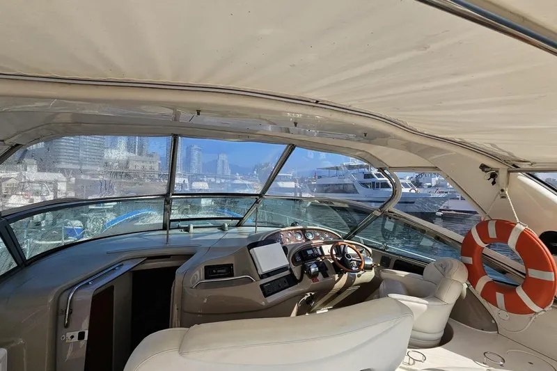  Yacht Photos Pics Interior view of 1999 Sea Ray 460 Sundancer yacht with helm and marina backdrop.